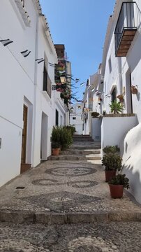 Flags and Village Street with Stairs in, Frigiliana, Nerja, Costa del Sol, Andalusia, Spain 