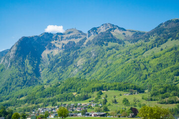 Naklejka premium Idyllic landscape in the Alps with fresh green meadows and mountain peaks.