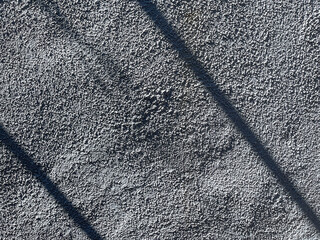 textured plaster wall with sunlight and shadows