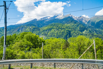 Idyllic landscape in the Alps with fresh green meadows and mountain peaks.