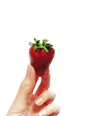 Woman holding a fresh strawberry with fingers