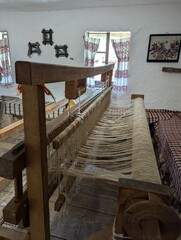 Traditional weaving loom in an interior of a wooden log hut