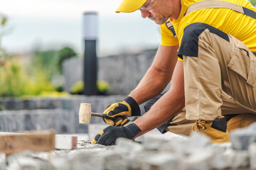 Worker Builds Outdoor Landscape With Stone Tools on Sunny Day