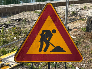 Work in progress sign positioned at the entrance of a construction site, indicating ongoing roadwork or building activities.