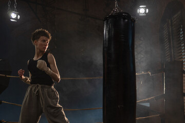 Female boxer training in cinematic gym lighting, powerful punch on bag with colorful dynamic lights