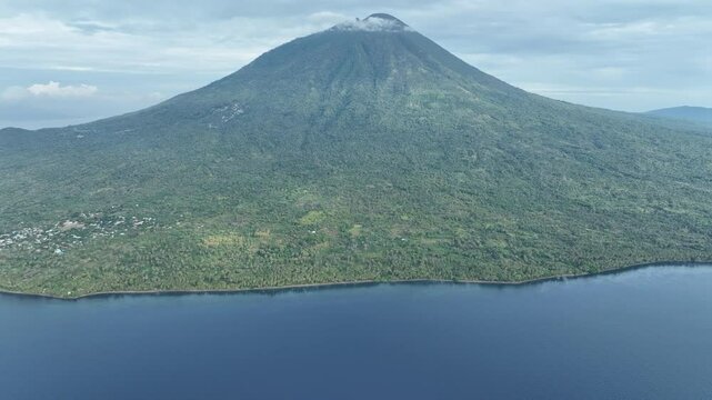 The volcanic island of Adonara, in the Lesser Sunda Islands of Indonesia, is fringed by palm trees along its coast. This tropical region supports some of the world's greatest marine biodiversity.