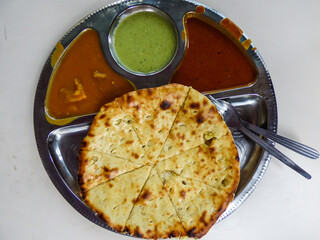 Garlic naan with 3 colorful sauces on a metal plate