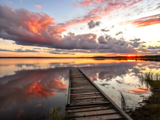 A Wooden Board walk into a lake with a beautiful sunset