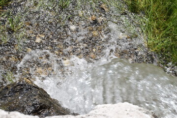 the water flows through the rocks. close up of the stream of water.