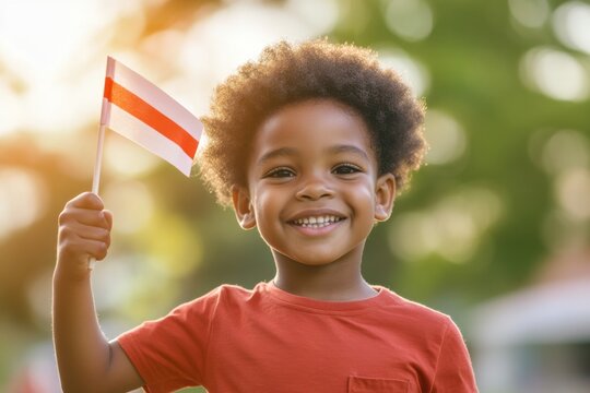 Happy boy waving flag in park - Powered by Adobe