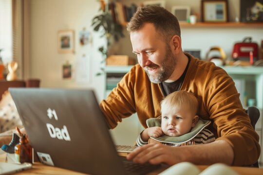 Father working from home holding his baby while using laptop