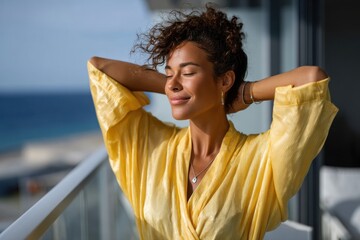 A serene woman relaxes on her balcony, basking in sunshine and serene sea views, radiating a sense of calm and inner peace in a tranquil environment.