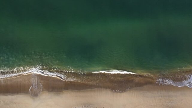 short waves on beautiful turquoise green water beach seen from above