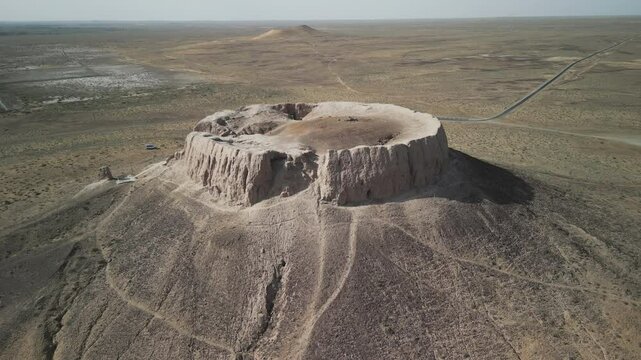 Drone view of Chilpik Dakhma rising from the desert plains. Ancient burial tower dates back to the 1st century BCE. A sacred site of Zoroastrian silence rituals