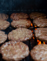 Overhead View: Beef Burgers Arranged on Grill Grate, Juicy Beef Burgers on Flaming Grill – Close-Up Shot