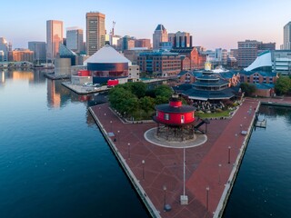 Baltimore Inner Harbor, USA, at dawn. The Seven Foot Knoll Lighthouse stands on a pier, with the...