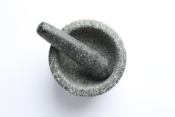 Stone mortar and pestle on white background, top view