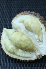 Fresh ripe durian on wicker table, closeup