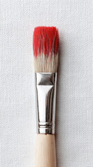 Paintbrush with red paint on bristles