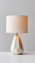 Modern white ceramic table lamp with fabric shade on white surface