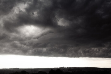 Dark turbulent clouds roll across the sky, casting a dramatic and almost cinematic atmosphere over...