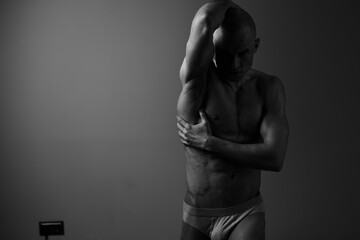 Black and white image of a strong man posing elegantly, showcasing his physique and expression in a...