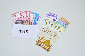 Indonesian Money, rupiah or IDR in envelope with THR Text. THR is holiday allowance on Eid al-Fitr or Lebaran days
Amplop THR or Angpao or Envelopes filled with money to be given to children or family