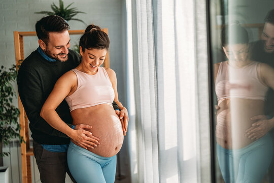 Man in love hugs his pregnant wife, they are waiting together for the baby's arrival. Love, family