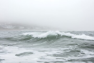 Fototapeta premium Misty Ocean Wave Breaking Near Shoreline in Foggy Weather Conditions