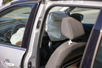 Crashed car with damaged front and opened airbags