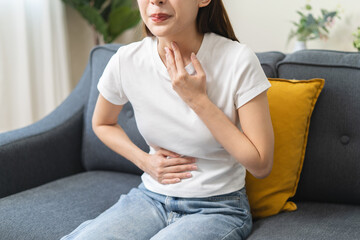 Close-up woman feel nausea touching her throat