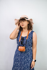 Beautiful young asian woman wearing blue summer dress and beach straw hat is suffering headache...