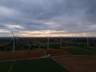 Aerial view of a wind turbine at sunrise, symbolizing renewable energy technology, clean power, sustainability, and environmental awareness.