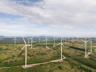 An aerial view of a wind turbine surrounded by lush green landscapes, symbolizing clean energy, sustainability, environmental awareness, and renewable energy technology.