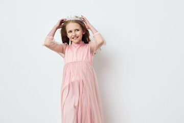 A joyful girl wearing a pink dress and a flower crown, celebrating joy and innocence in a bright,...