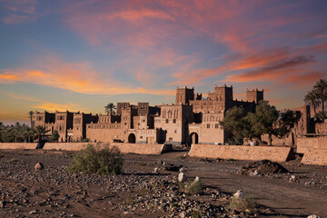 Adobe buildings line a dry riverbed.