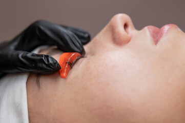 Caucasian woman undergoing eyelash lamination procedure. 