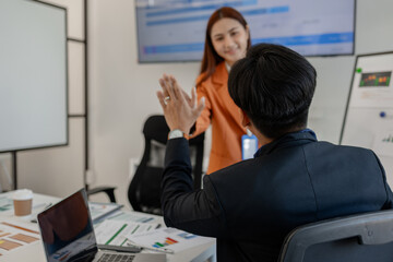 the group of business people showed their joy by clapping and giving high fives because of their...