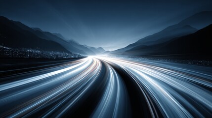 Obraz premium Long exposure night shot of a highway with light trails through the mountains.