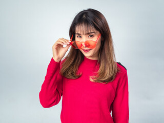 Asian woman in red sweater posing with yellow sunglasses, slightly smiling with confident and...