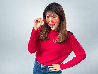 Asian woman in red sweater posing with yellow sunglasses, slightly smiling with confident and...