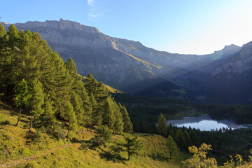 Mountain panorama with summit Quille du Diable ou Tour Saint-Martin, lake Lac de Derborence and sunbeams in the morning of Swiss Alps, Switzerland