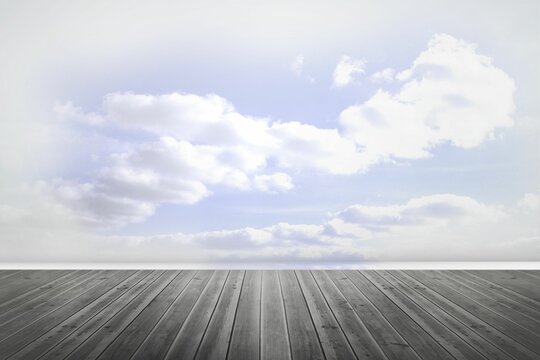 Fototapeta Minimalist wooden plank floor is stretching toward divider in flat style, with cloudy sky backdrop