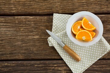 Orange slices in bowl with knife and napkin on table © vectorfusionart
