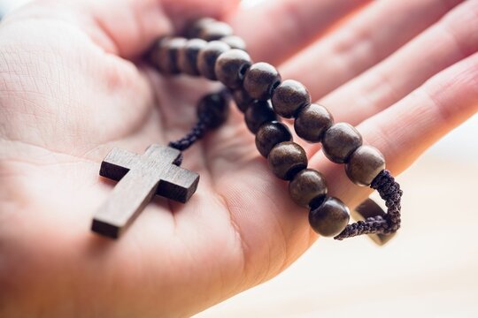 Hand holding rosary beads