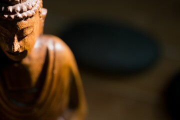 Close-up of Buddha statue by pebbles