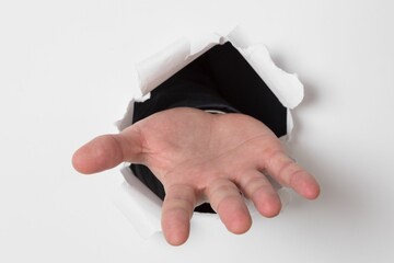 Hand ripping through paper