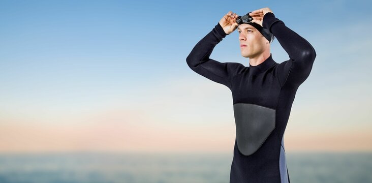 Fototapeta Male swimmer looking away while standing on shore