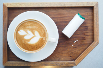 Coffee and artificial sweetener on a wooden tray 
