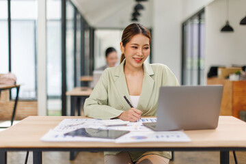 Shot of a asian business female working on laptop computer in her workstation.Portrait of Business...